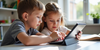 Two children are studying and using tablet computers together.