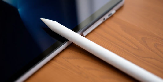 Apple Pencil alongside an iPad Pro on a table.
